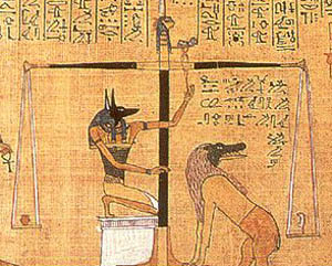 This detail scene from the Papyrus of Hunefer (ca. 1375 B.C.) shows Hunefer's heart being weighed on the scale of Ma'at against the feather of truth, by jackal-headed Anubis. Ibis-headed Thoth, scribe of the gods, out-of-shot records the result. If Hunefer's heart is lighter than the feather, Hunefer is allowed to pass into the afterlife. If not, he is eaten by the waiting Ammit. Scenes such as these were common illustrations in Egyptian books of the dead.
