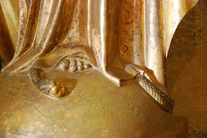 A statue of Mary crushing the snake underfoot. The snake obligingly identifies himself as the serpent from the Garden of Eden with an apple in his mouth A statue of Mary crushing the snake underfoot.