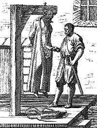 This man has been hanged and is now being drawn - ie having his bowels removed